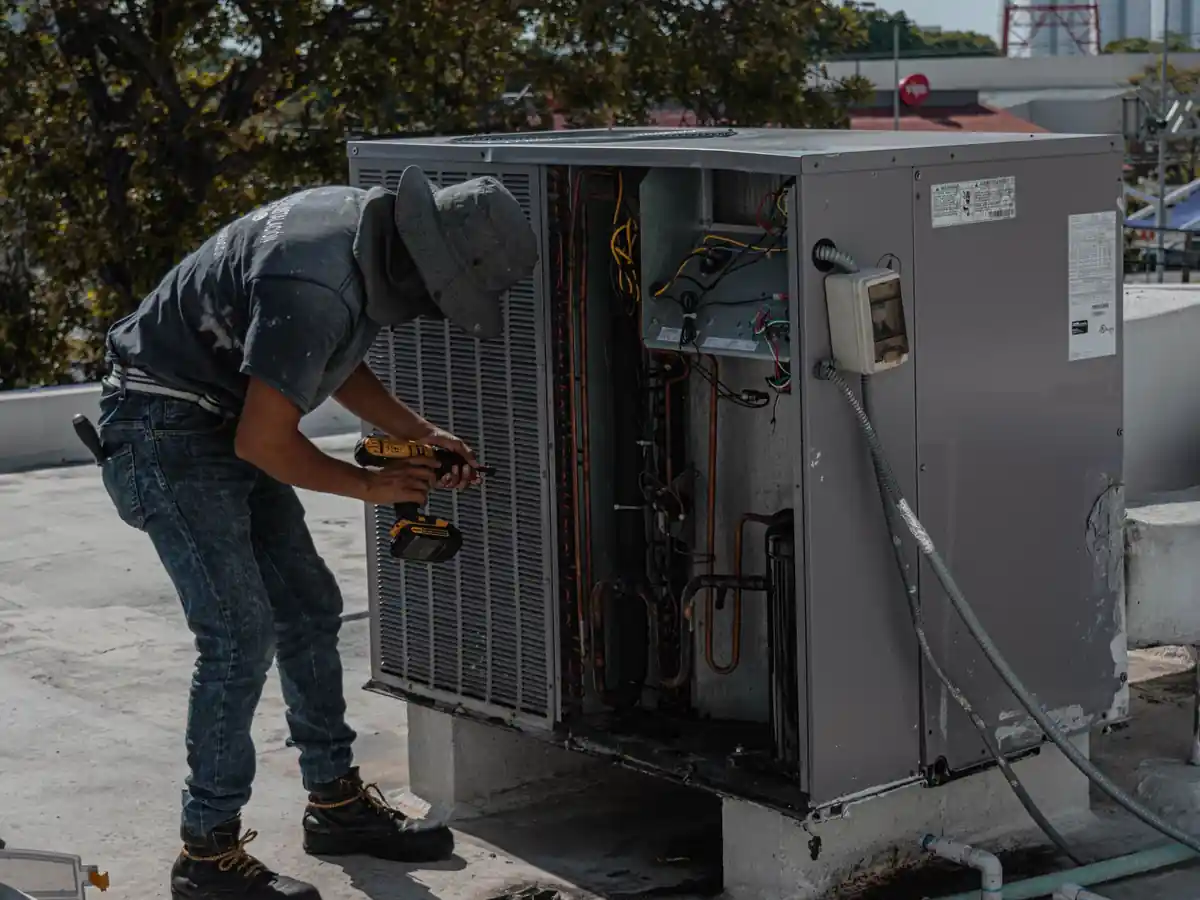 Technician servicing a rooftop air conditioning unit