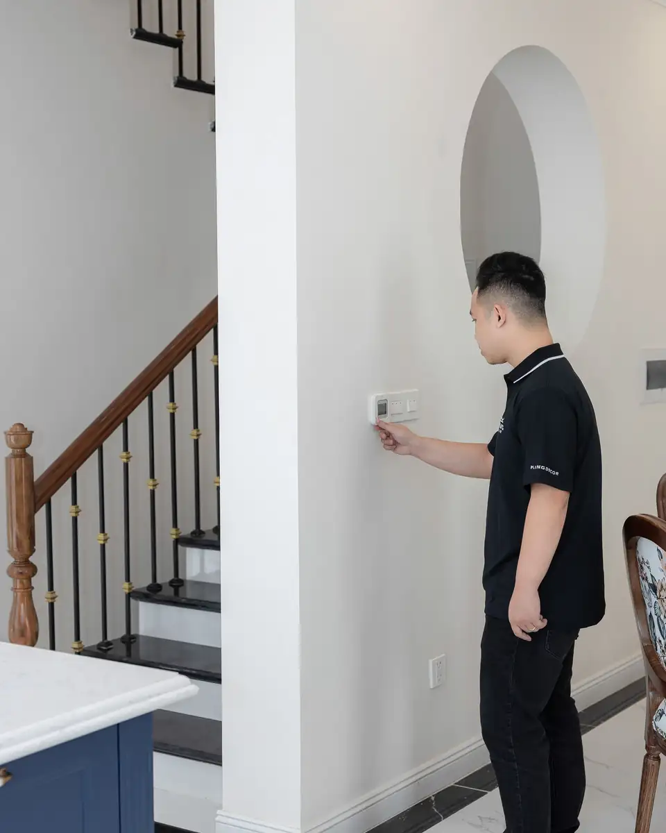 Technician adjusting a thermostat in a home