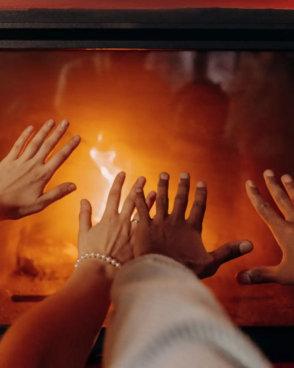 Hands warming by a fireplace