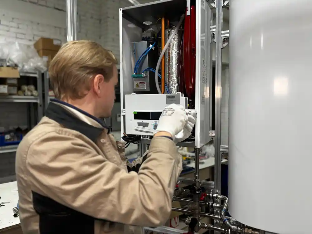 Technician servicing a wall-mounted home boiler