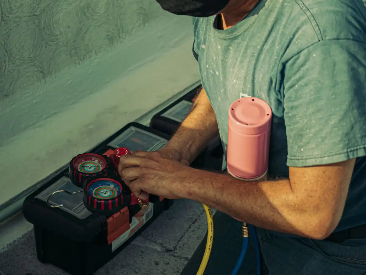 Technician kneeling outdoors performing HVAC maintenance
