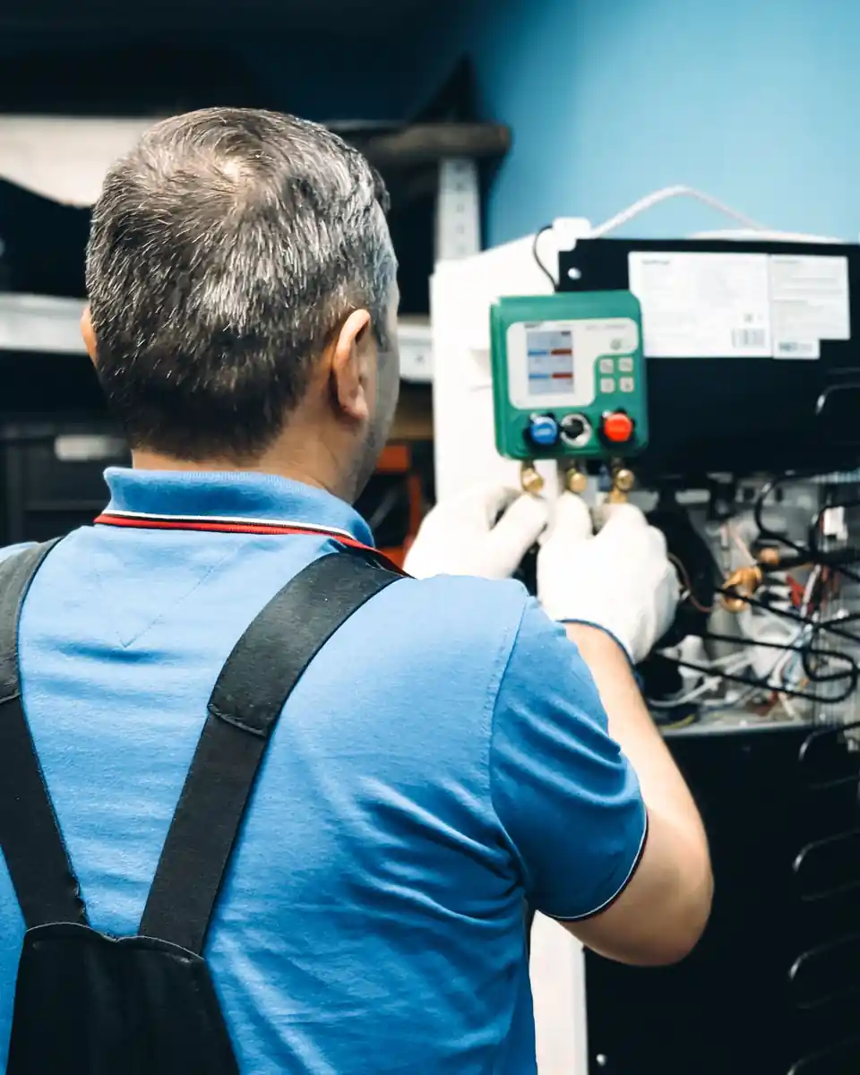 Technician working on an air conditioning system indoors