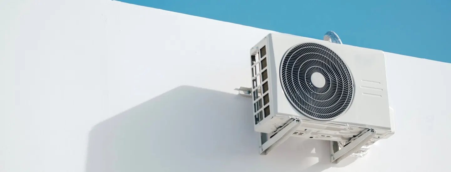 Outdoor air conditioning unit against a clear blue sky