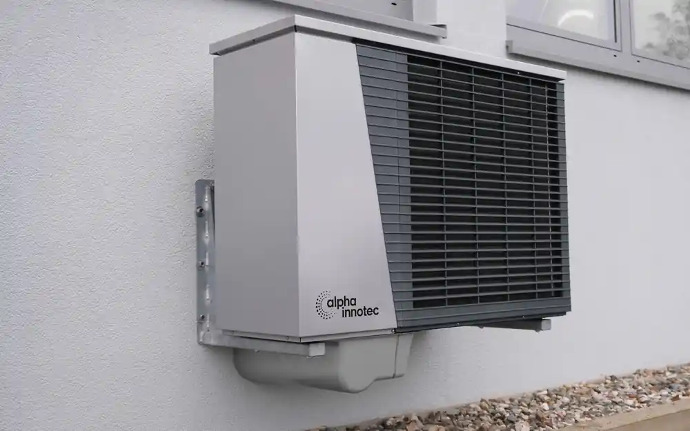 Outdoor heat pump mounted on a home exterior wall