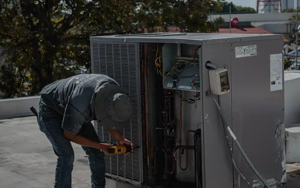 Technician repairing a rooftop air conditioning unit