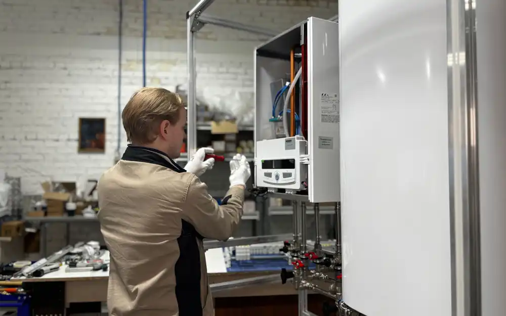 Technician servicing a wall-mounted home boiler