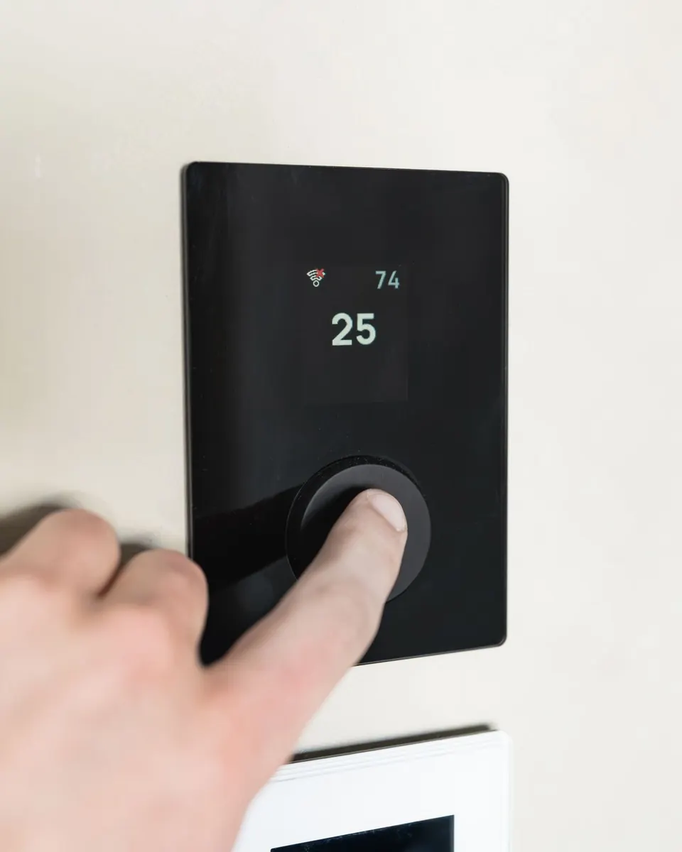 Hand adjusting a digital smart thermostat