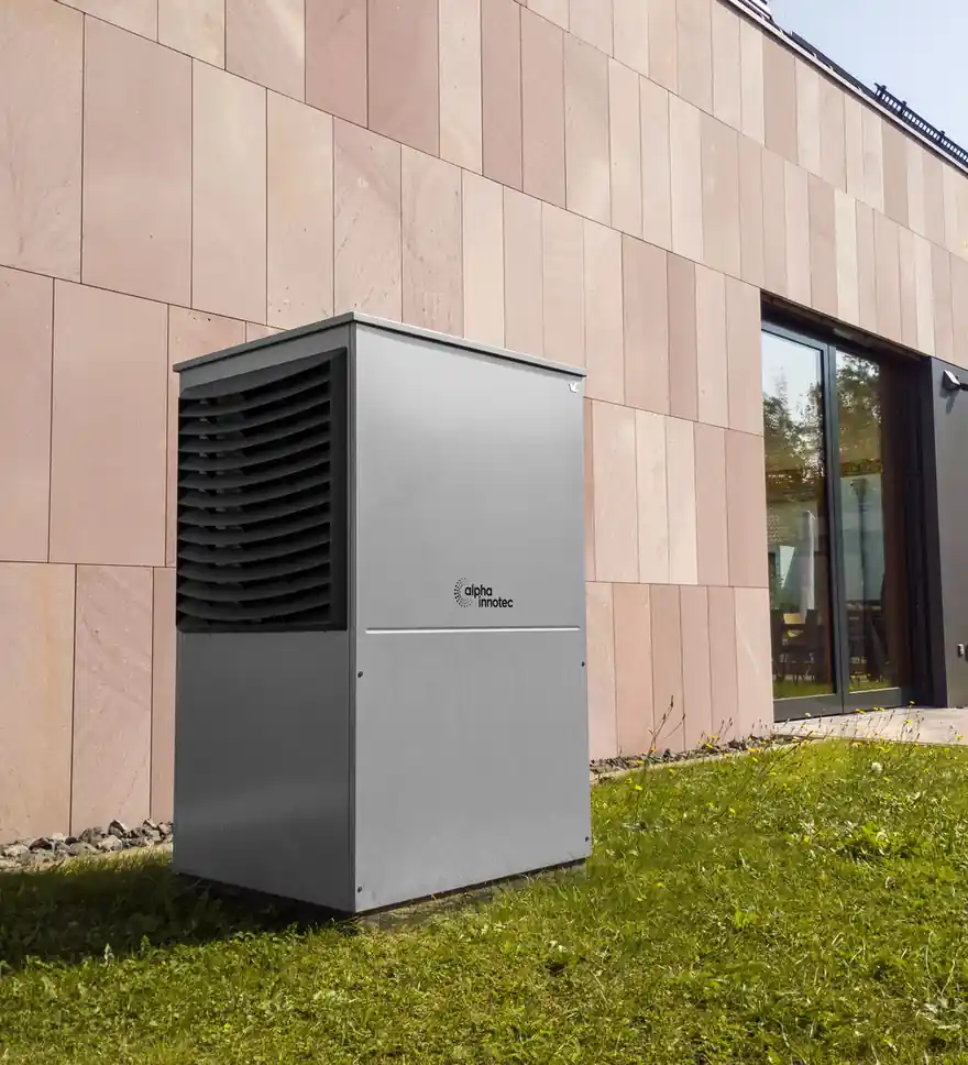 Modern outdoor heat pump beside a new building