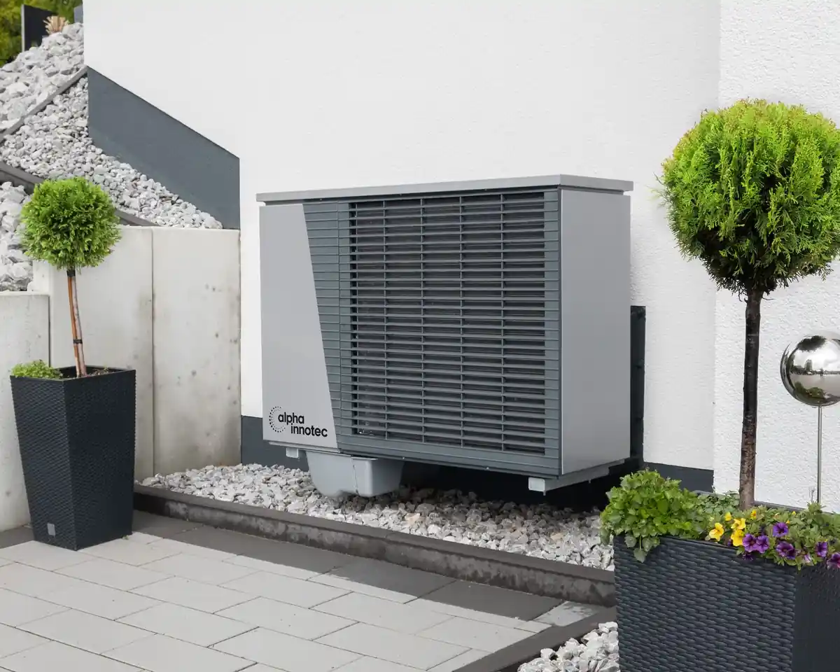 Outdoor air conditioner with flower pots beside a home