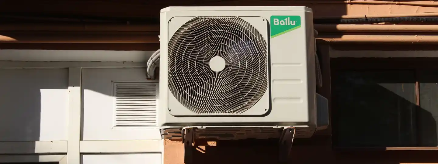 Air conditioner condenser unit on a building exterior