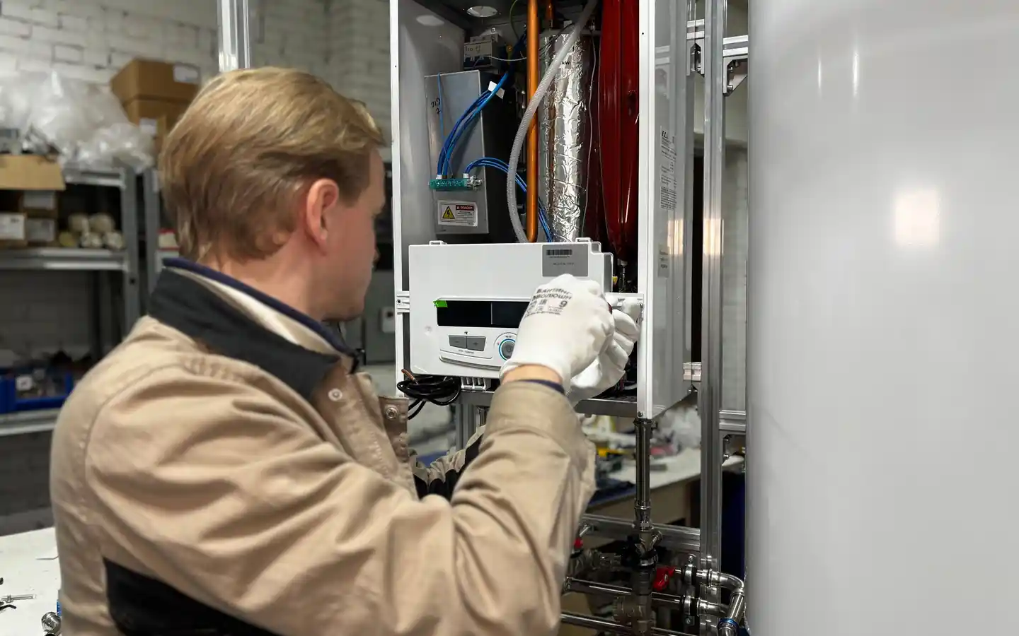 Technician servicing a wall-mounted home boiler