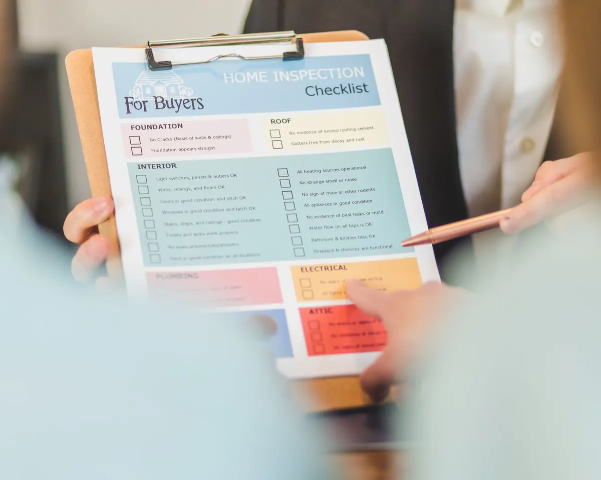 Hands holding a home inspection checklist on a clipboard