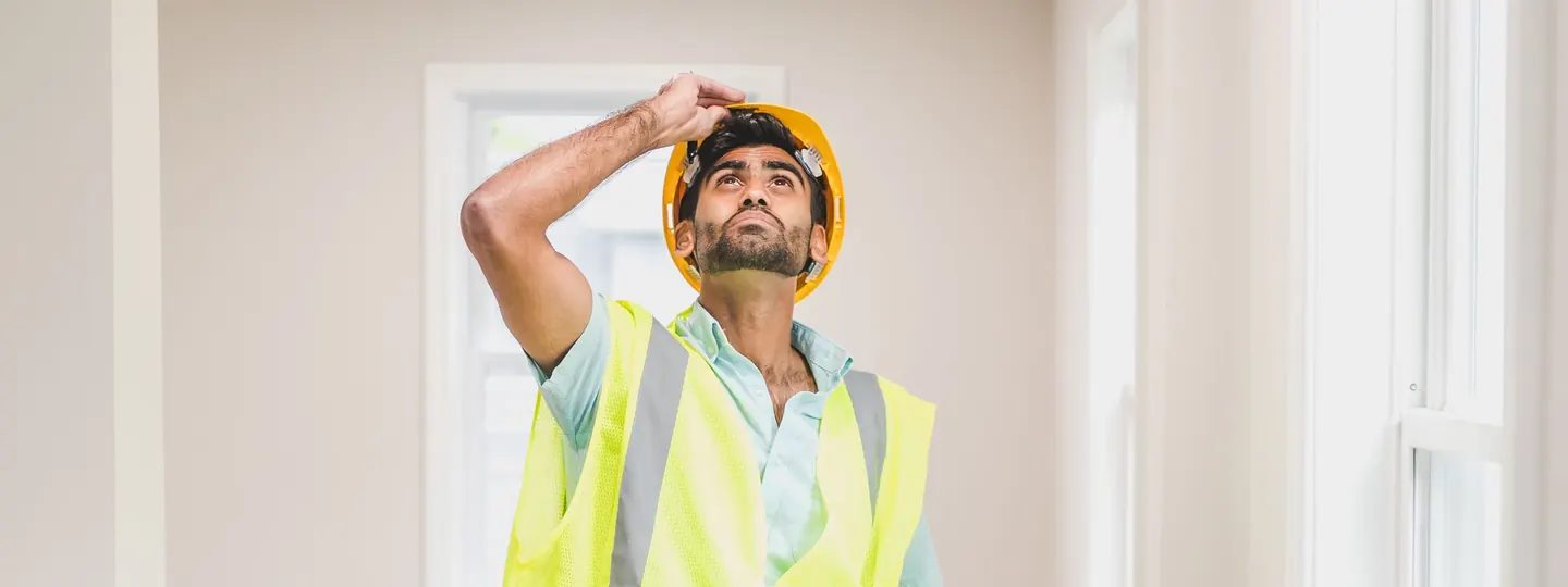 Inspector in a safety vest examining a house interior