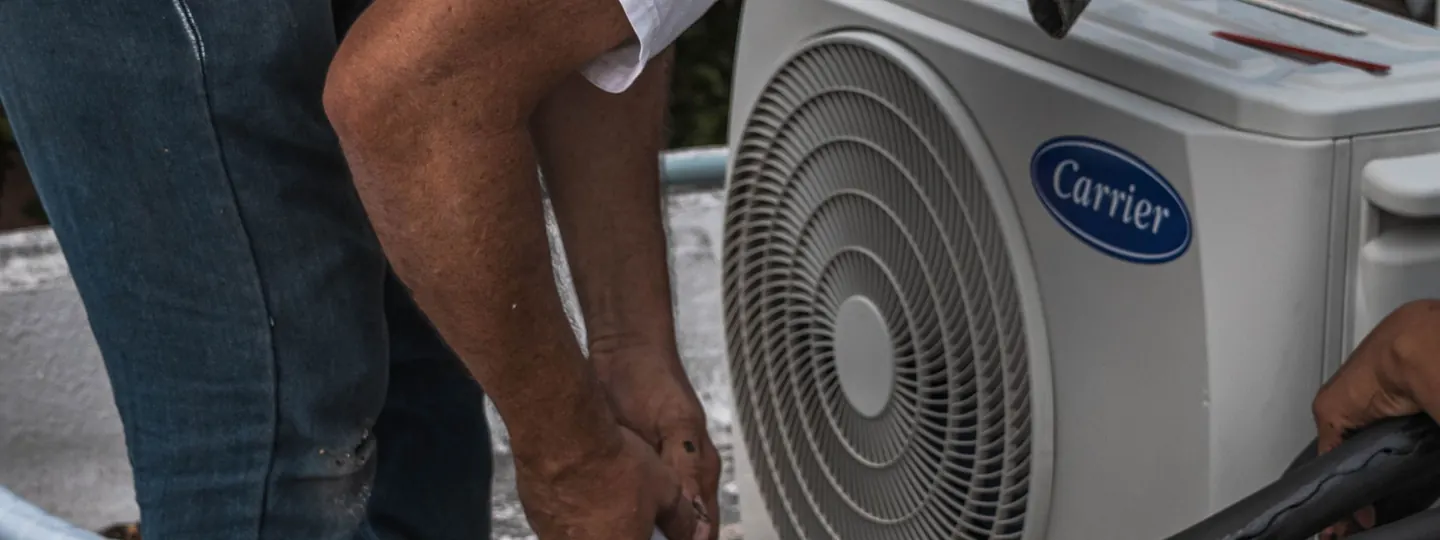 Technician performing maintenance on an outdoor air conditioning unit