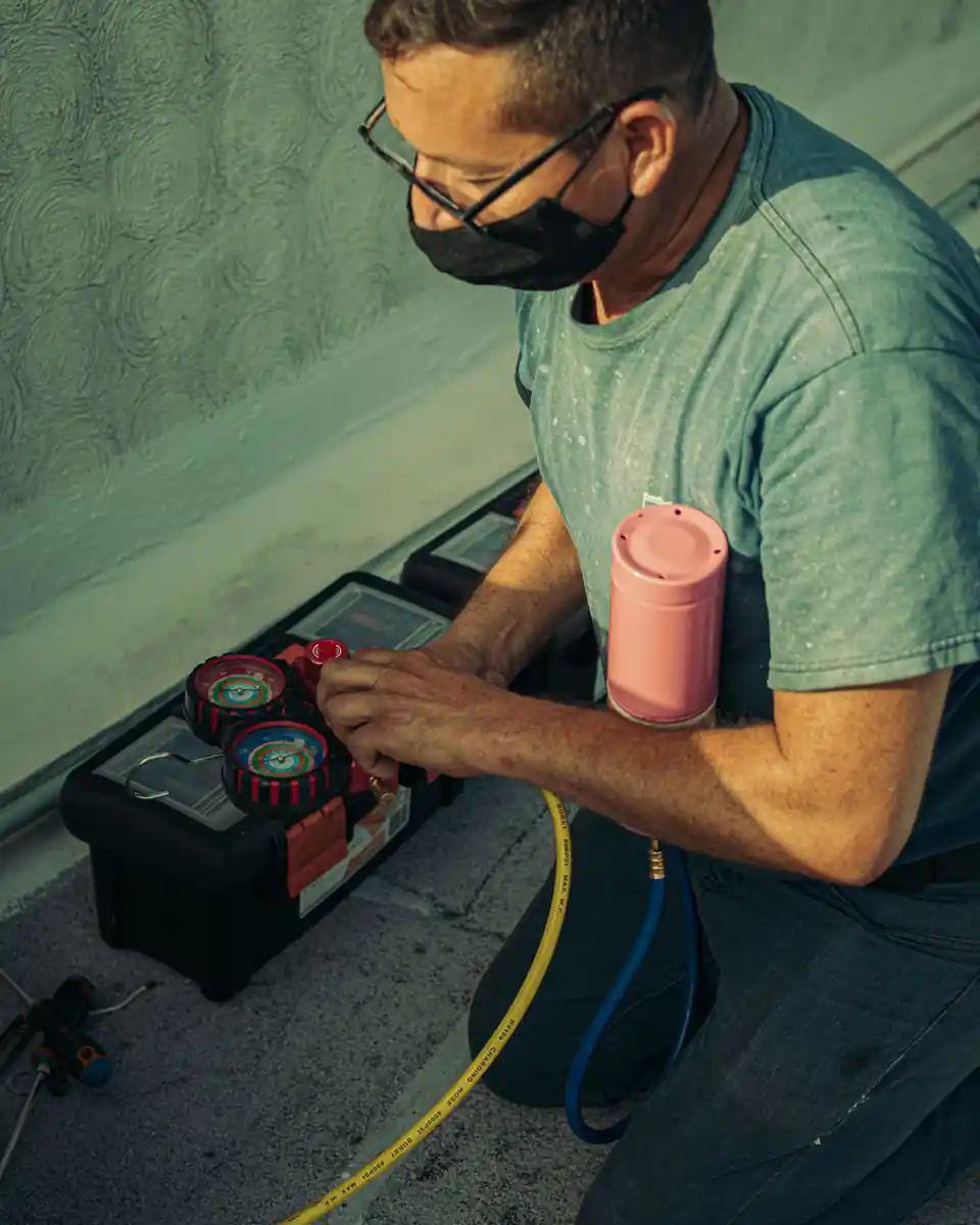 HVAC technician checking refrigerant gauges during a service call